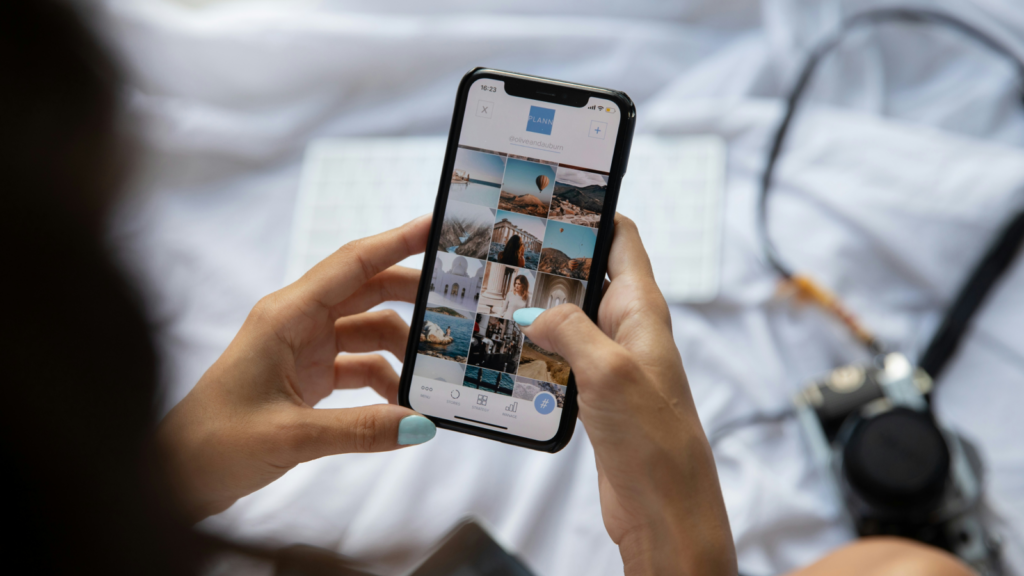 A woman holding a mobile phone in her hands with the Instagram app open on the screen.