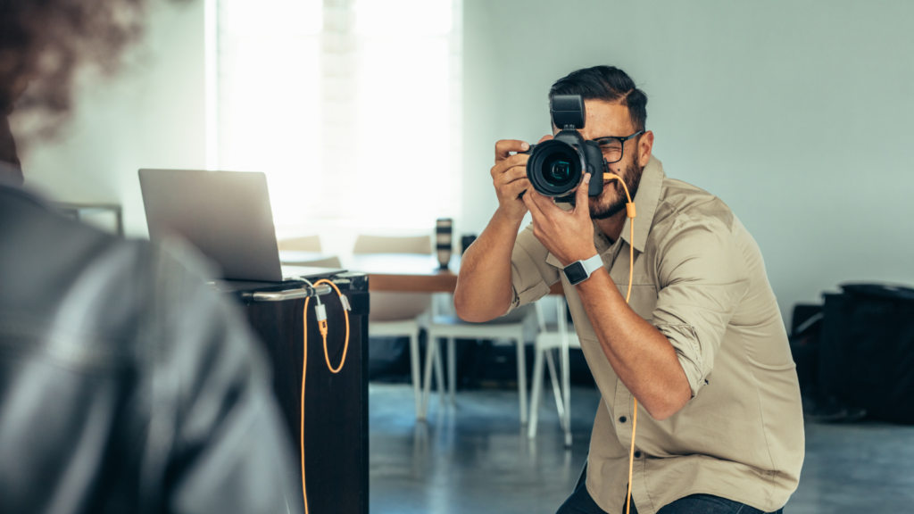 A man capturing an image with a camera, focused on his subject in an outdoor setting.