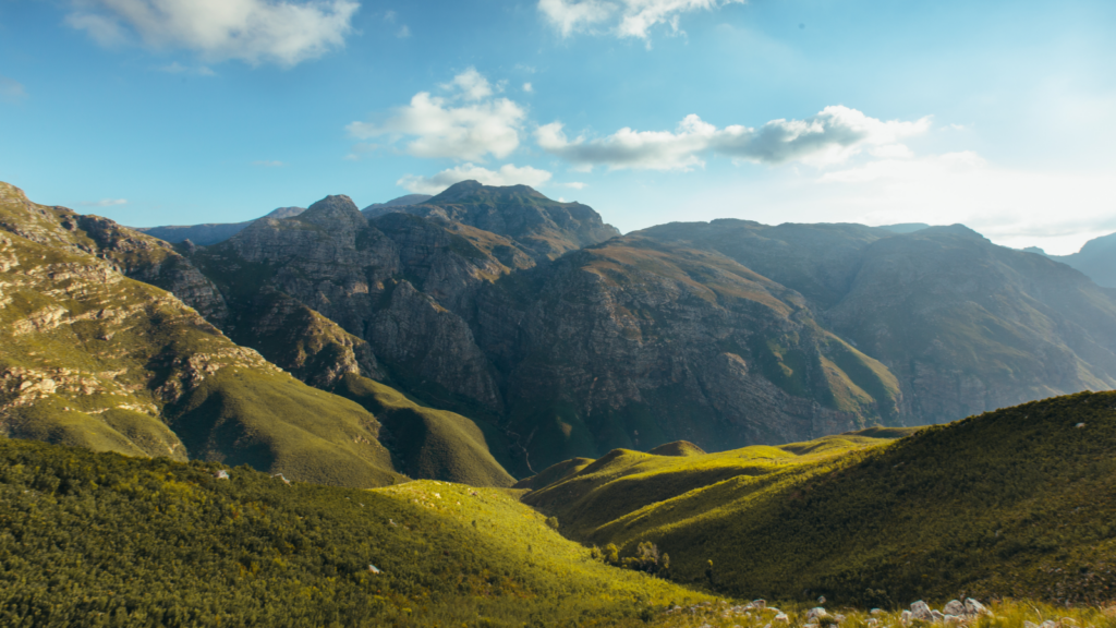Scenic view of majestic mountains under a clear blue sky, showcasing their rugged peaks and natural beauty.