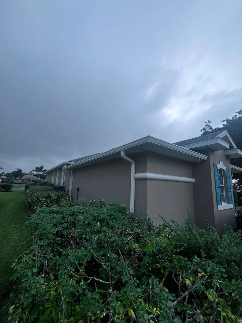 Seamless gutters running along a landscaped home exterior