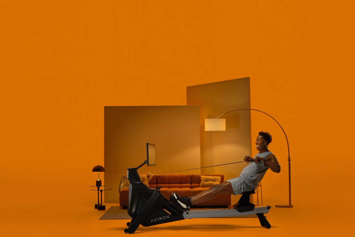 Man using an Aviron rowing machine playing an on-screen game