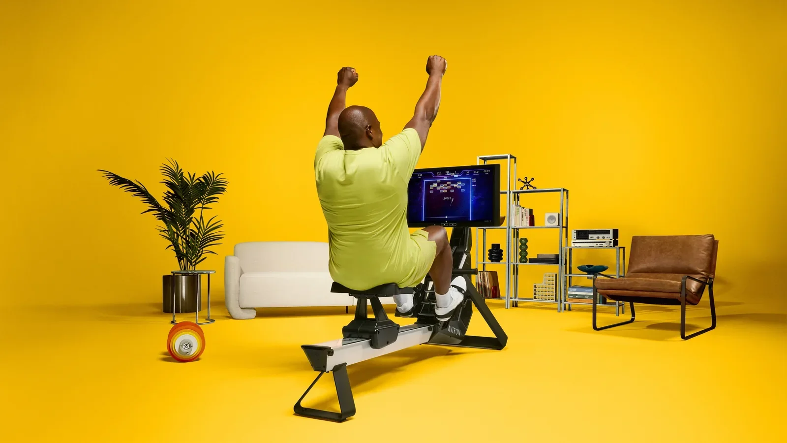 Person celebrating a rowing workout milestone at home