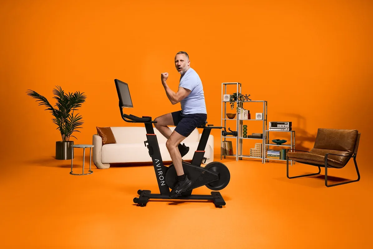 Man riding an Aviron Fit Bike S in a living room