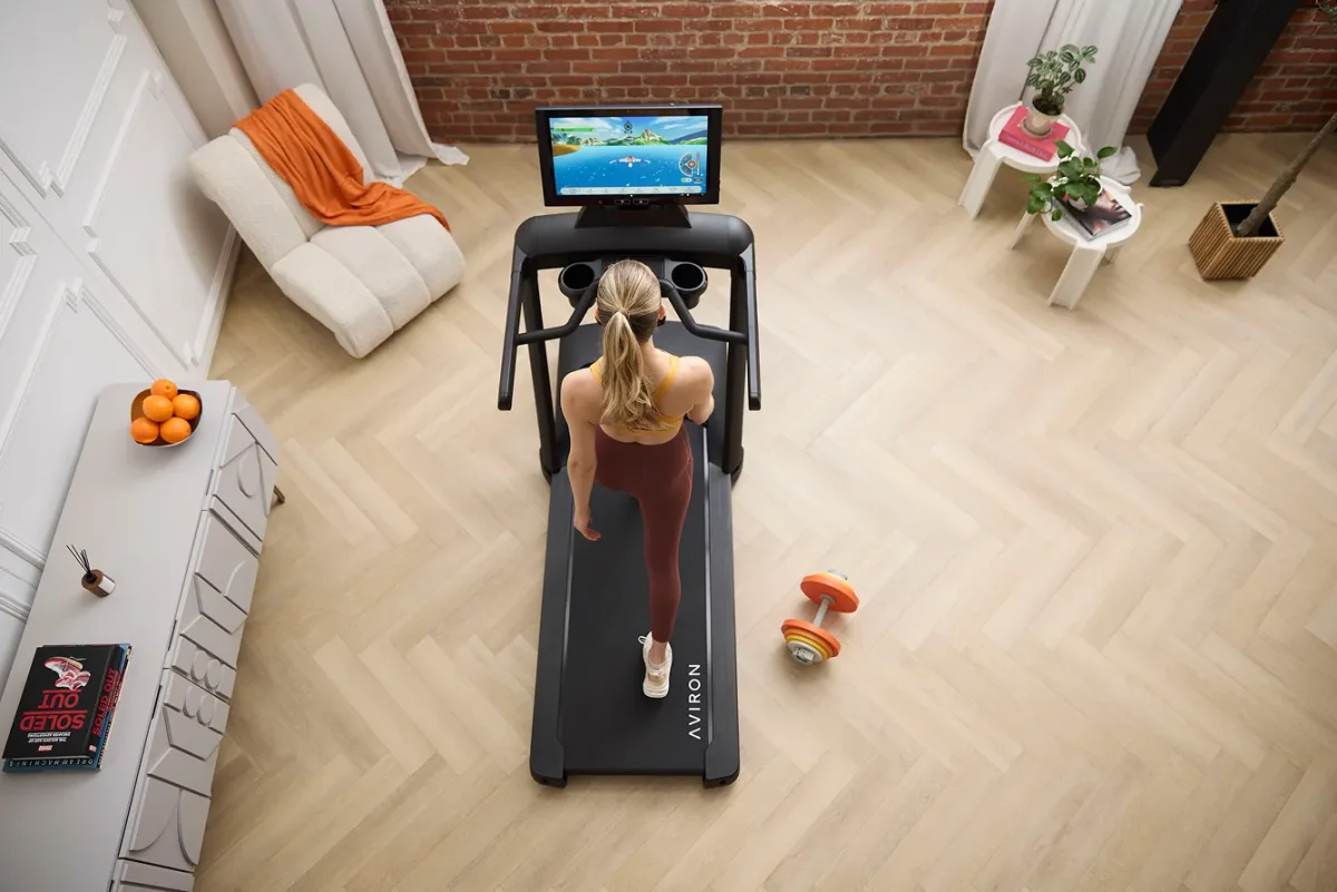 Overhead view of a woman running an interval workout on an Aviron Victory Treadmill at home