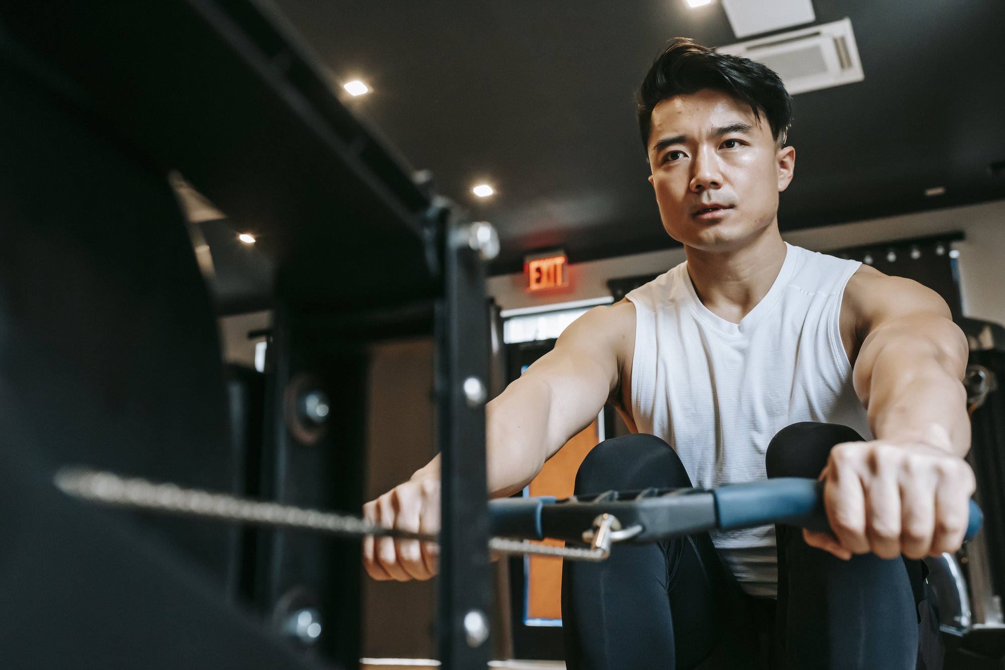 Close-up of a rower pulling through the stroke, showing upper-body and core engagement.