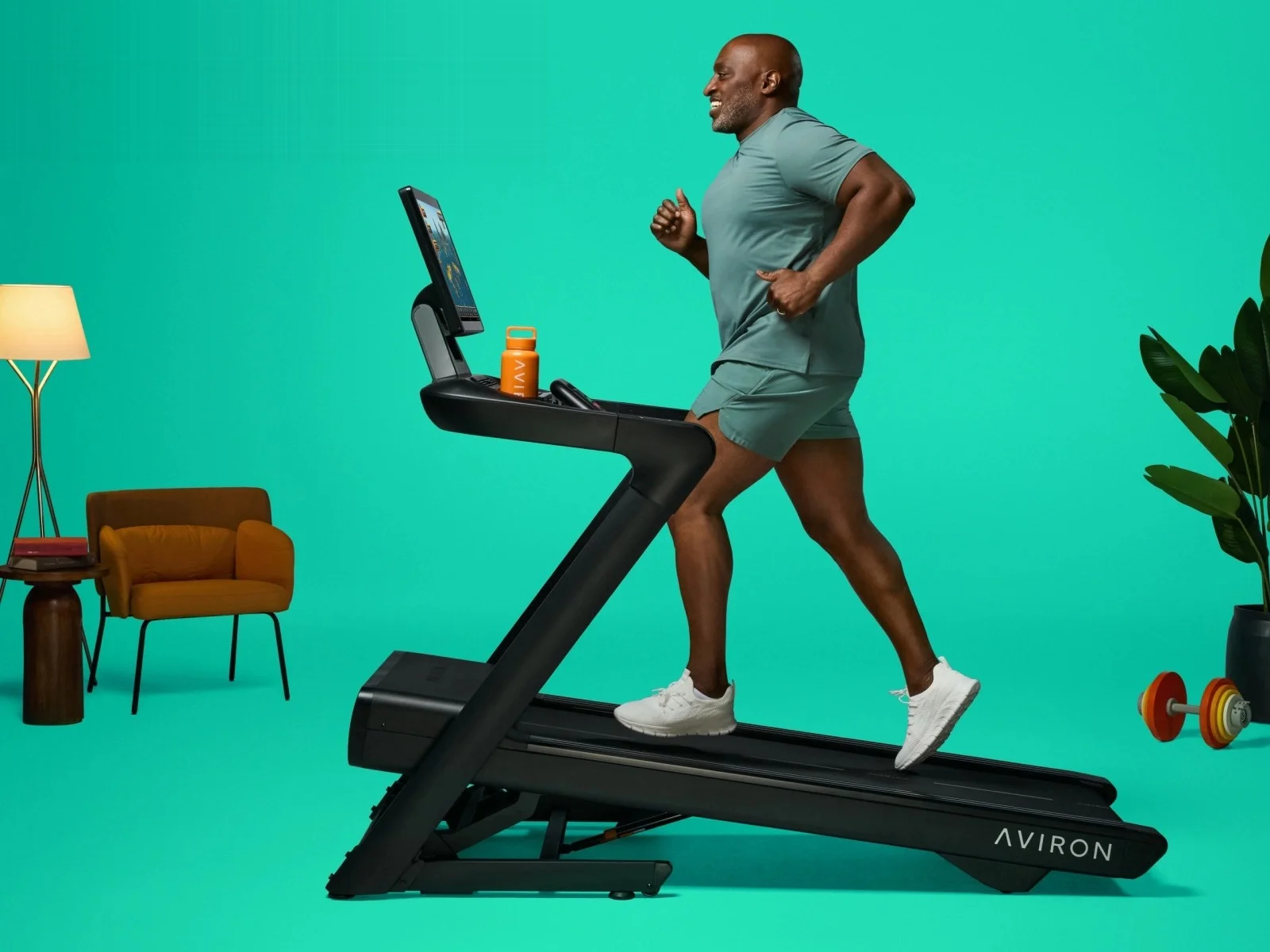 A runner at pace on an Aviron treadmill set to an incline, showing the deck length and frame a good treadmill needs
