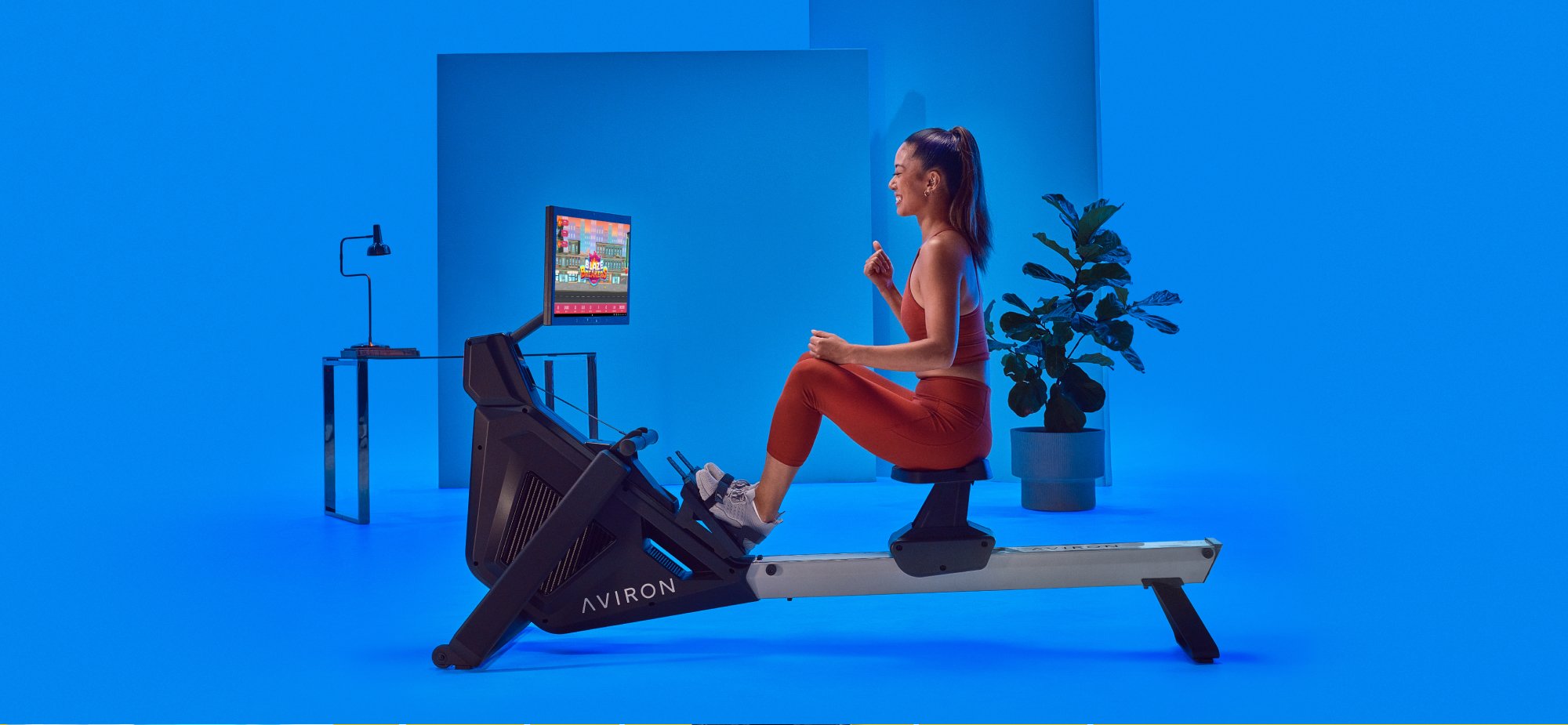 Girl playing the Blaze Breakers game onscreen on Aviron rowing machine