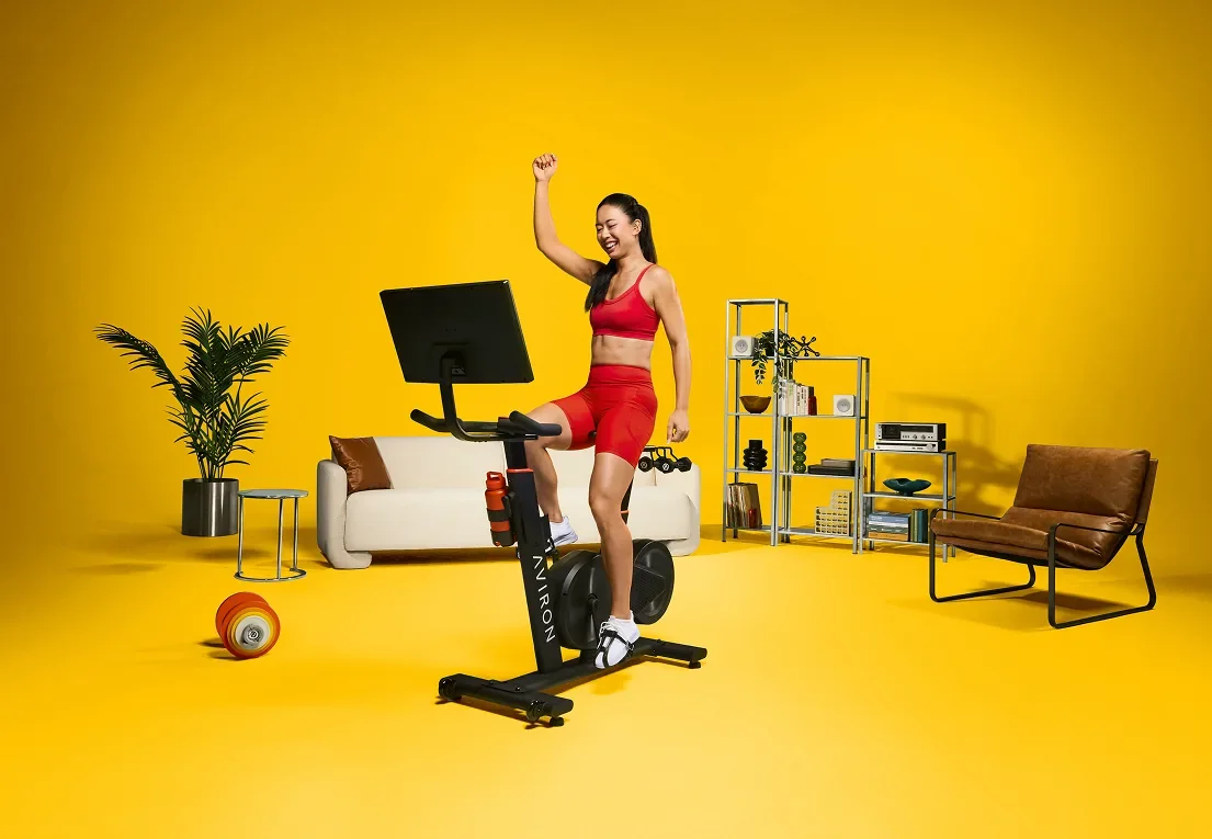 Woman riding an Aviron Fit Bike S stationary bike at home