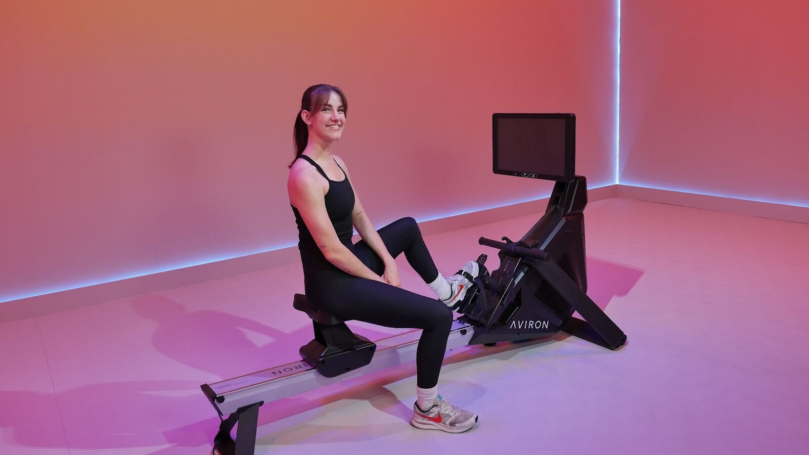 Aviron rower with a touchscreen display during a beginner rowing session.