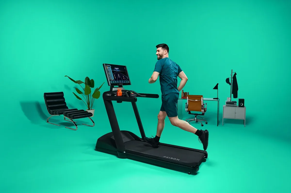 Overhead view of an Aviron treadmill showing a scenic route on screen at home