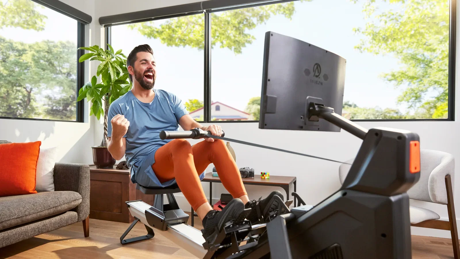 Man celebrating after a full-body rowing workout at home