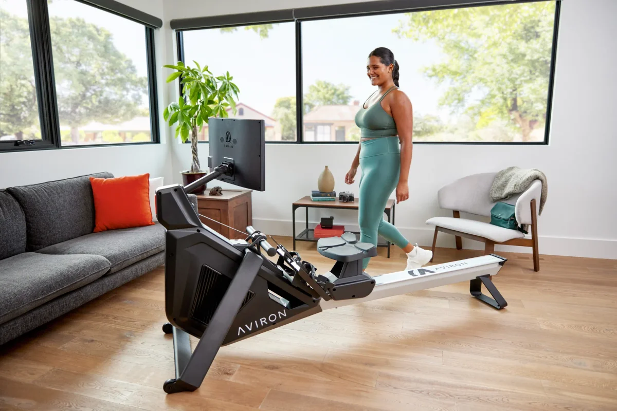 Woman walking up to an Aviron Strong Rower for a fat-loss home workout
