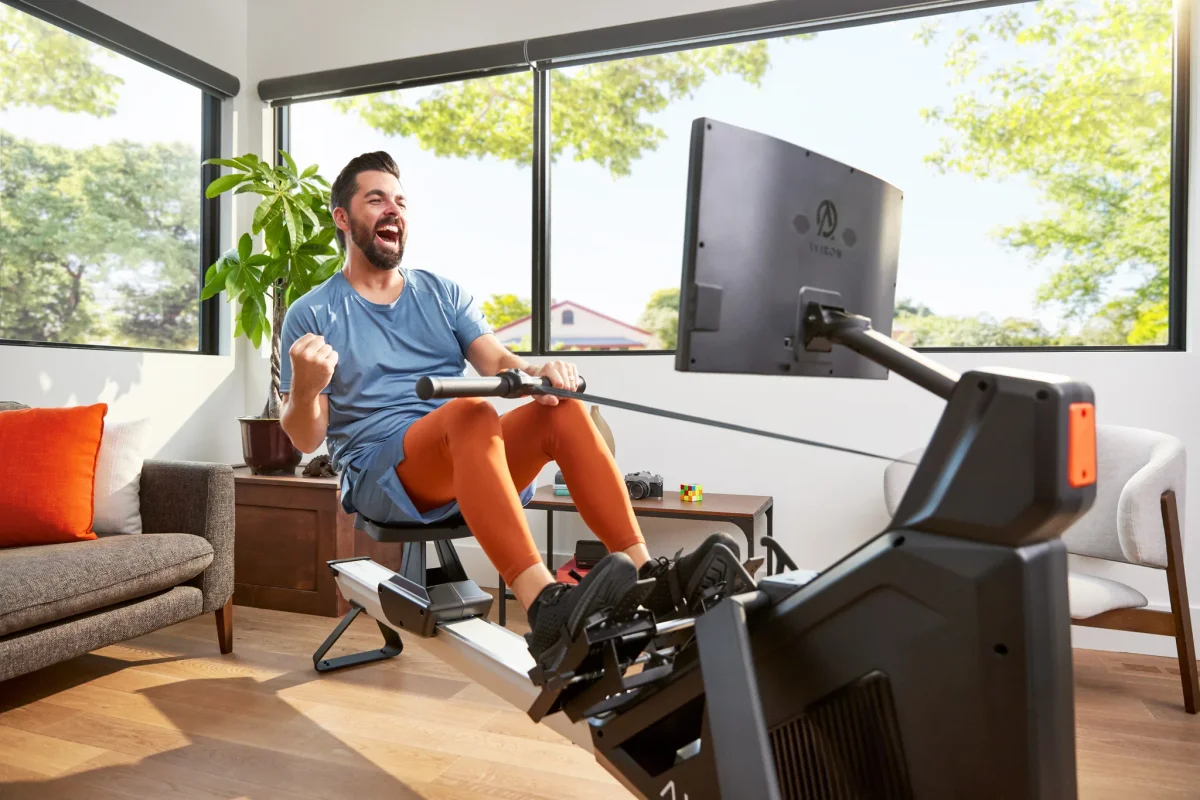 Rower pulling hard through the drive on an Aviron Strong Rower at home while training for a faster 2000m split time