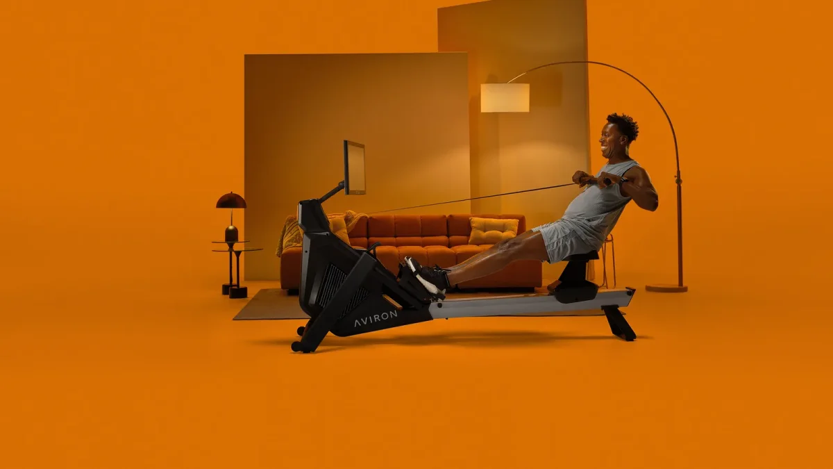 Beginner rowing at full extension on an Aviron Strong Series Rower at home