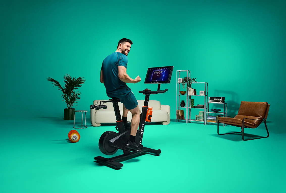 Man following a beginner stationary bike workout plan on the Aviron Fit Bike S screen