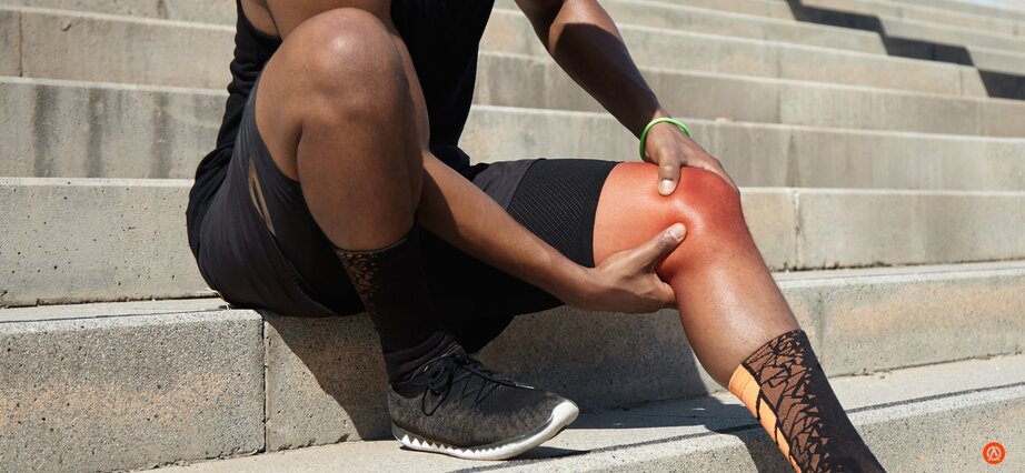 Man touching sore knee from rowing injury