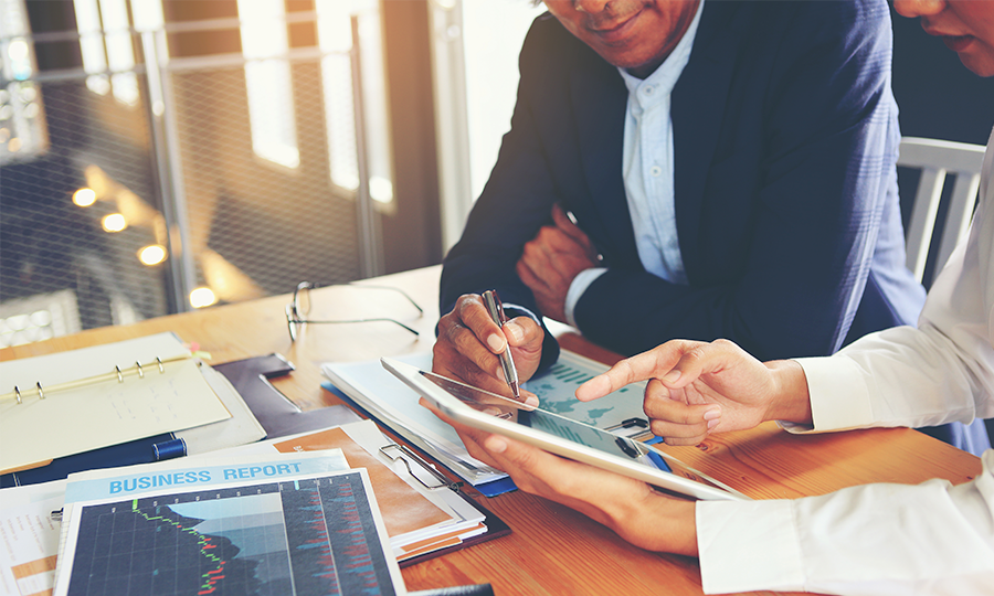 Two management consultants reviewing business reports