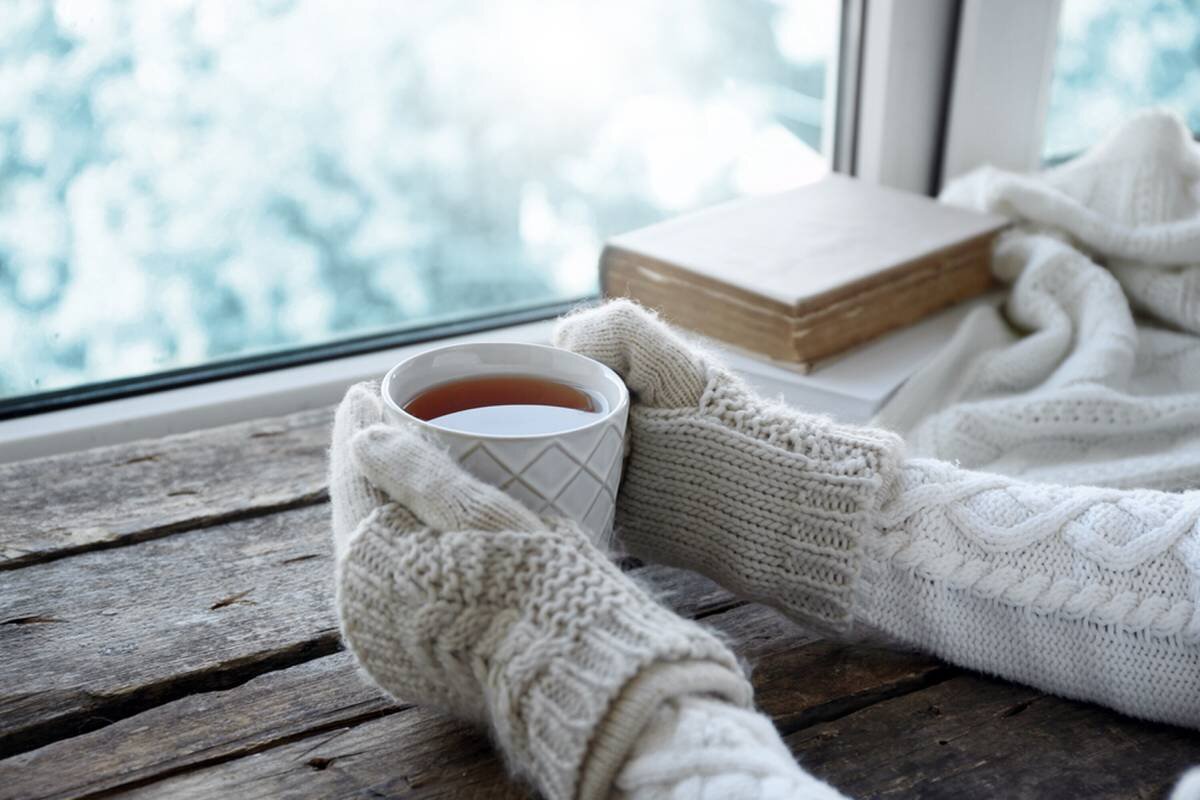 Holding cup of tea with wool gloves