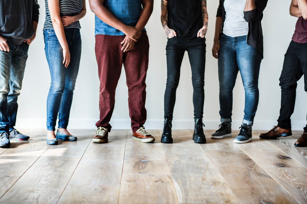 A group of people standing together, with the image focusing on their legs