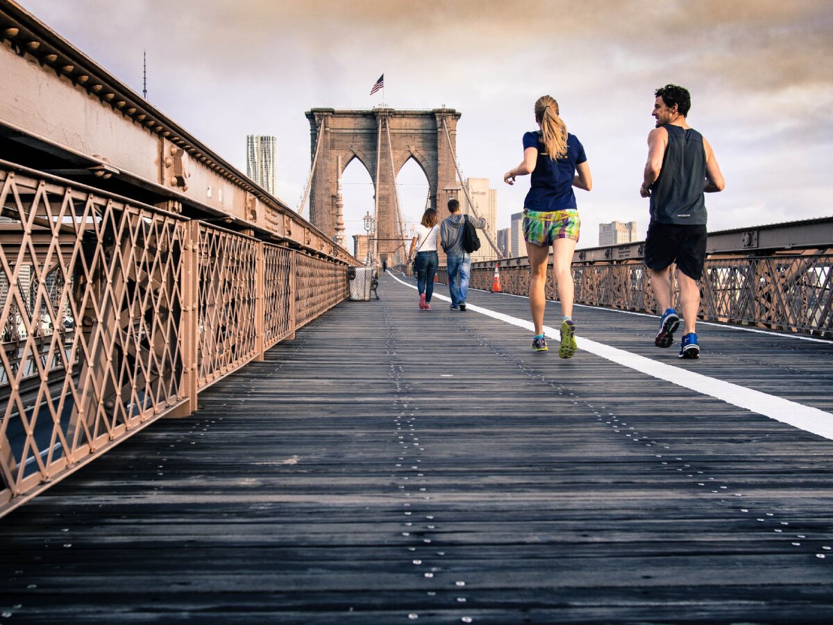 People running across a bridge.
