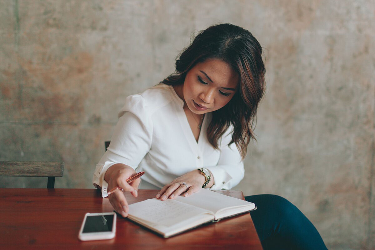 Young woman taking notes on her notebook