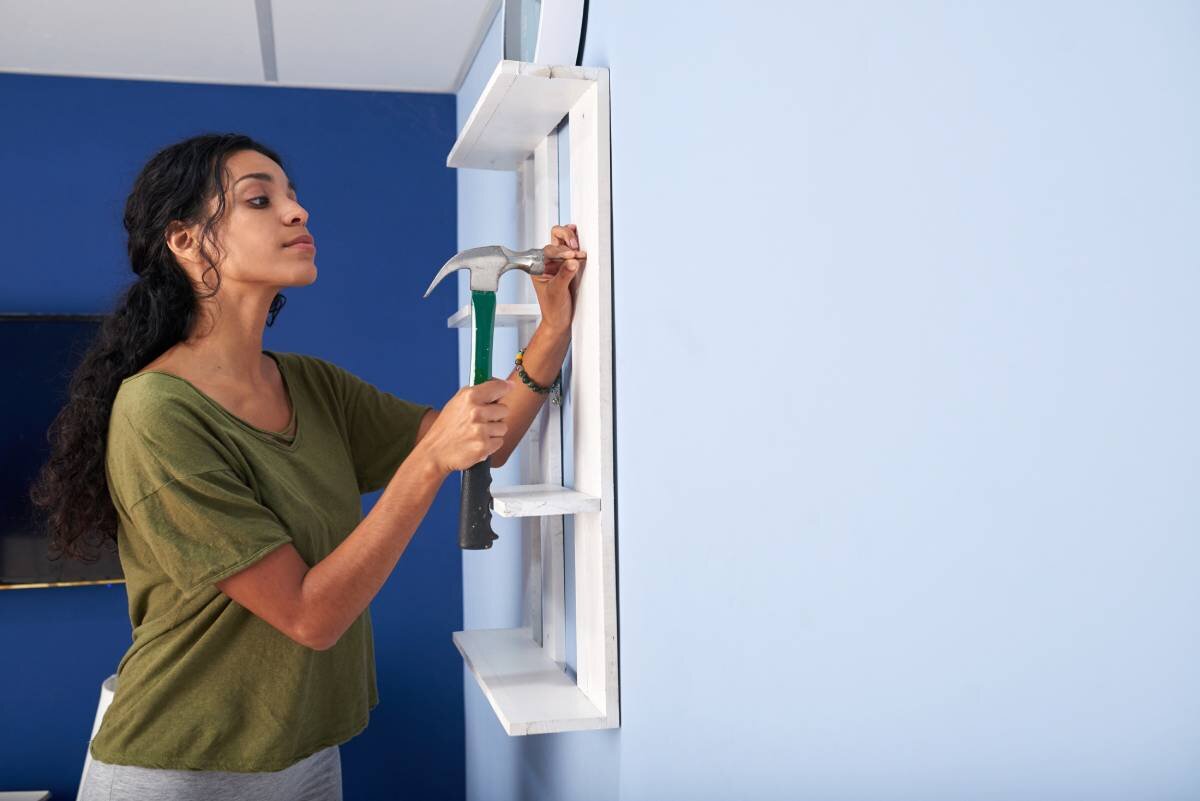 Woman hammering shelf