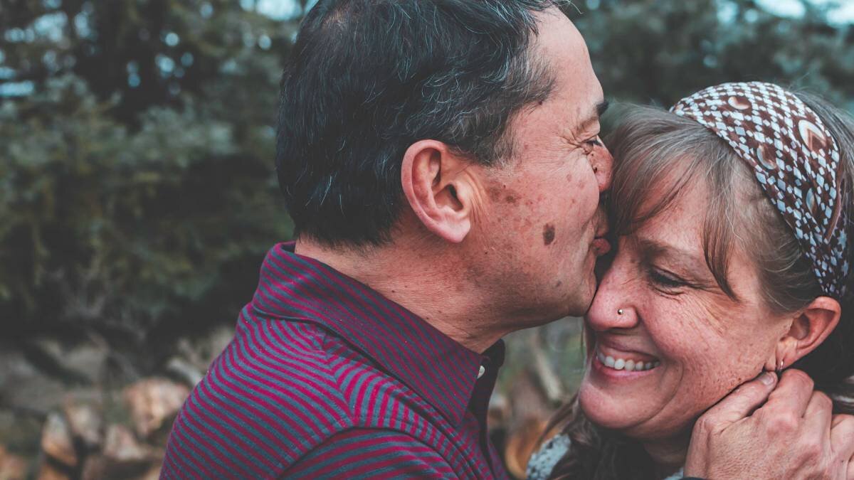 Old man kissing a woman's forehead