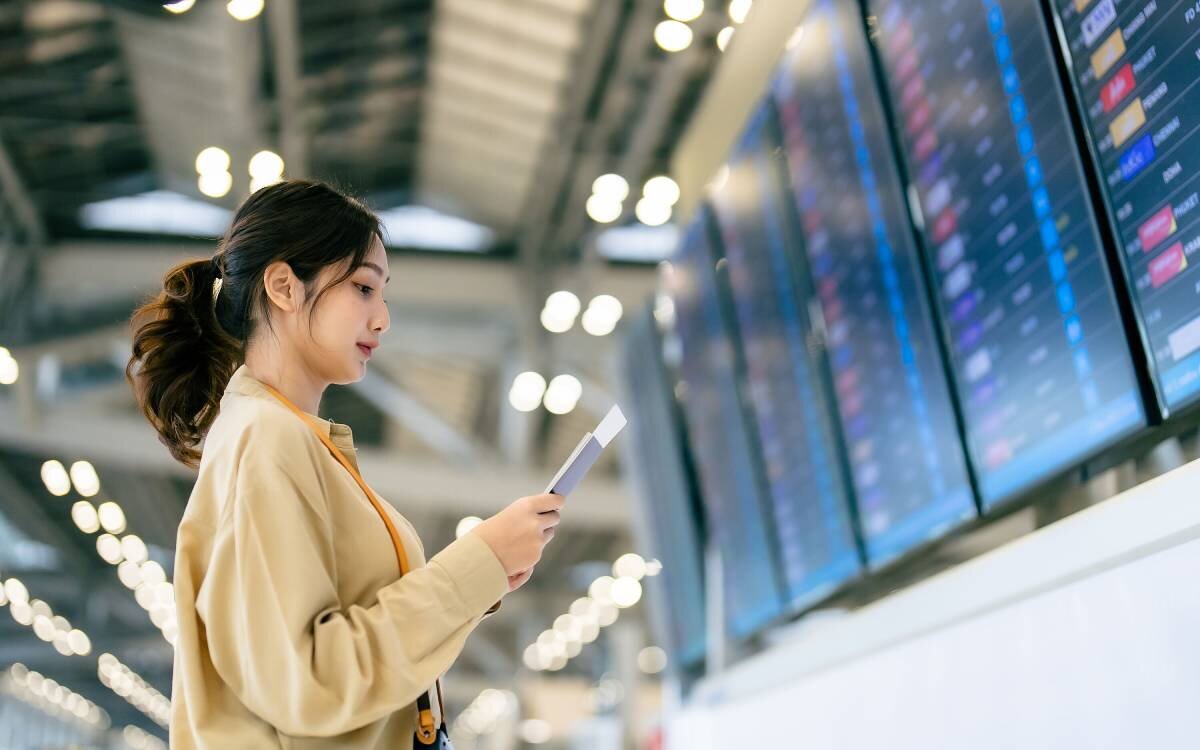 woman looking at departures screen at the airport