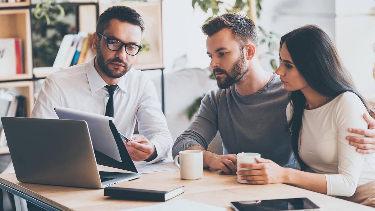 Executive showing life insurance plan to a couple