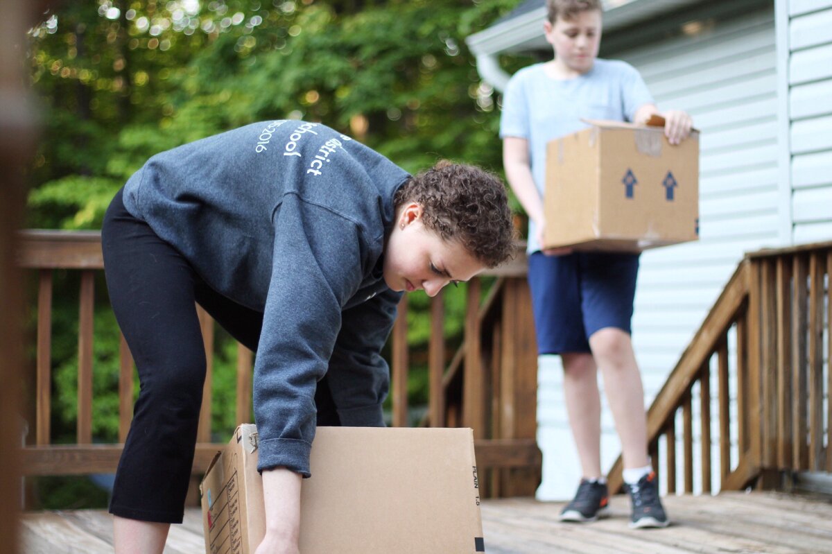 A person lifting a box off the floor for a move