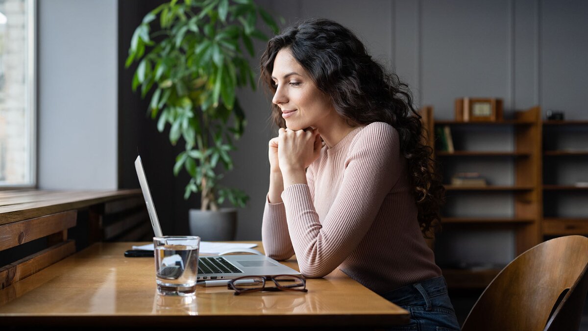 woman sitting at her desk, looking at her computer