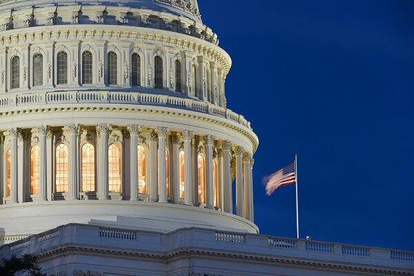 Partial view of US Capitol dome with American flag