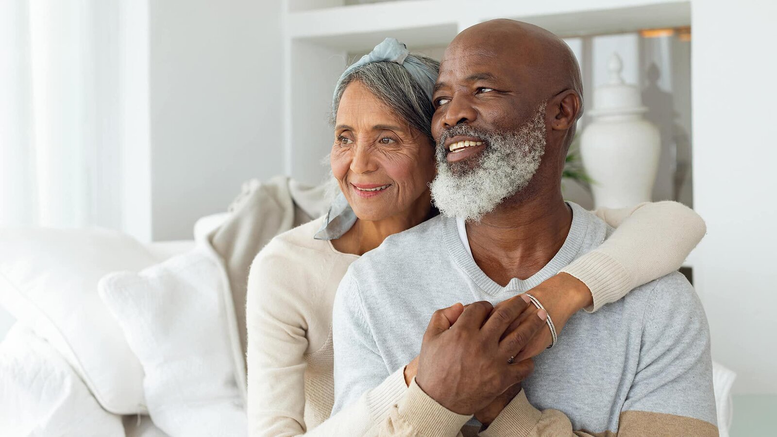 Happy older couple embracing and smiling together indoors