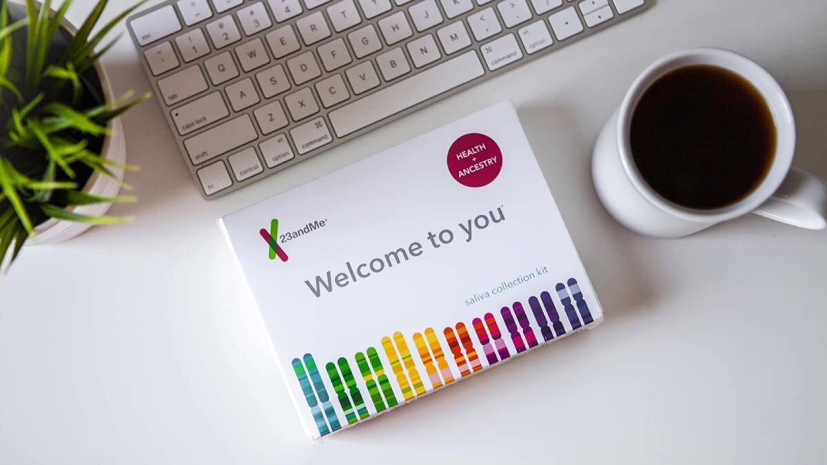 Keyboard, coffee cup, and a saliva collection kit on a desk