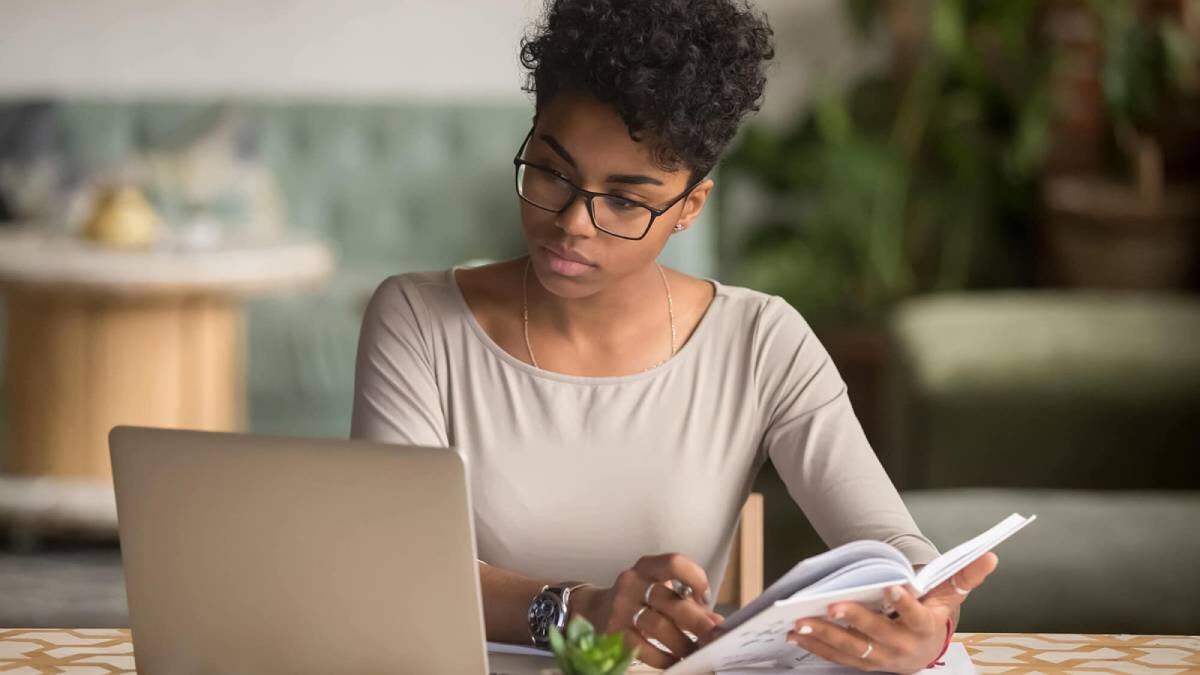 woman reading and looking at her laptop