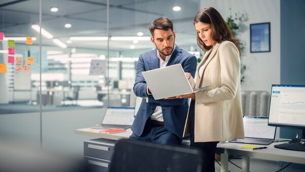 A manager and college collaborate with a laptop