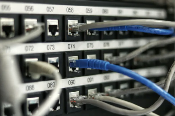 A bunch of ethernet cables plugged into the back of a unit