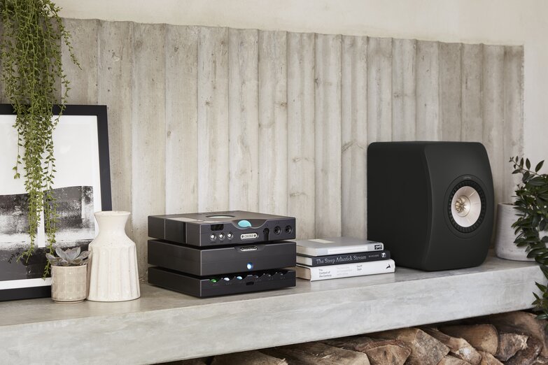 Hugo M Scaler stack on marble shelf with bookshelf speaker and knick-knacks