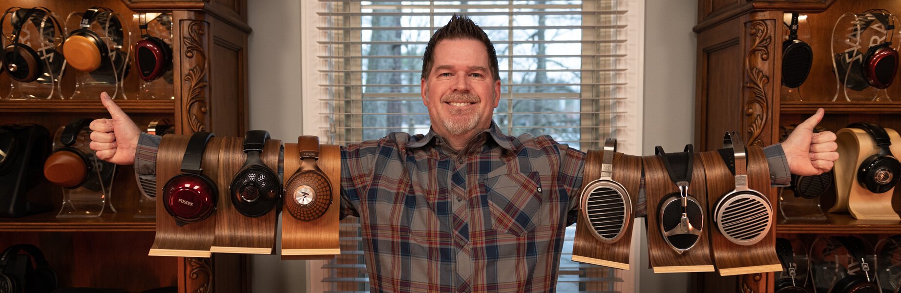 Moon Audio CEO Drew Baird holding Headphones on each arm 