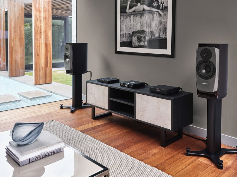 hugo tt 2 amp in a music room on a cabinet between standing speakers