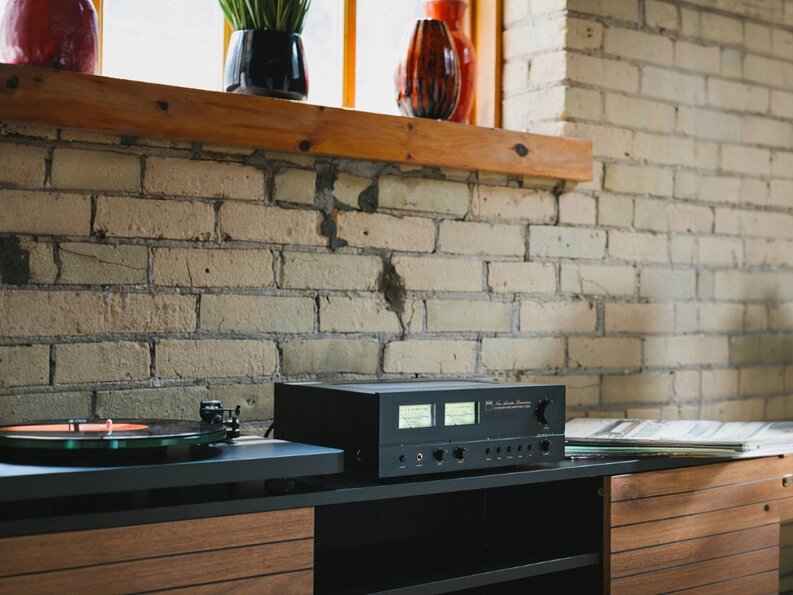 C 3030S Stereophonic Amplifier on entertainment center against brick wall