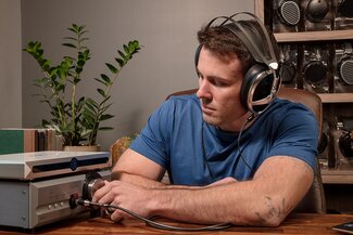 Man wearing Meze Audio headphones connected to a Pass labs hpa-1 amplifier