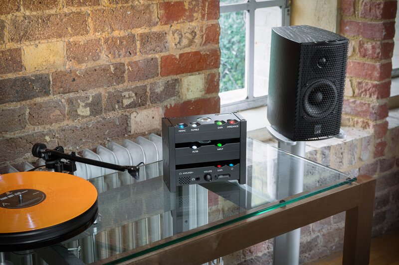 Chord Electronics Anni Amplifier on table next to turntable and speaker