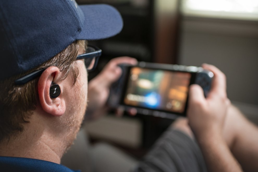 Man playing switch with wireless earbuds