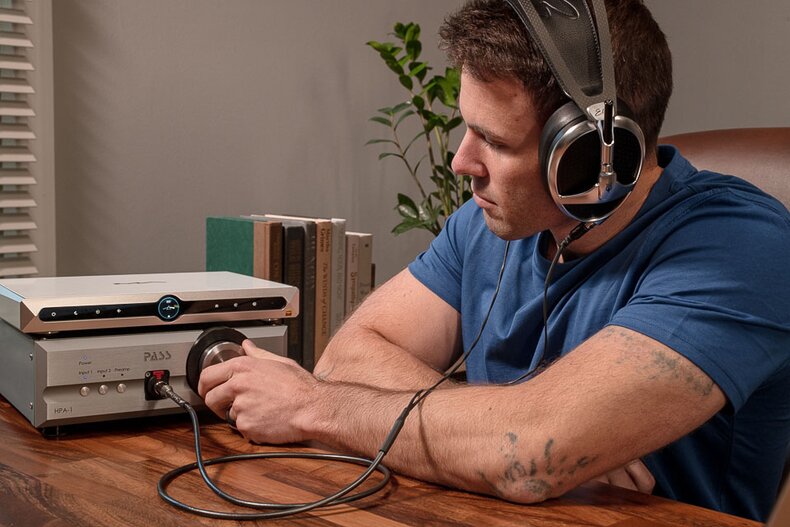 Gentleman listening to headphones and adjusting volume on the Pass Labs HPA-1 Headphone Amplifier