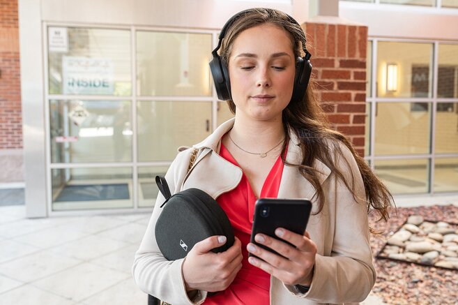 woman with headphones looking at phone