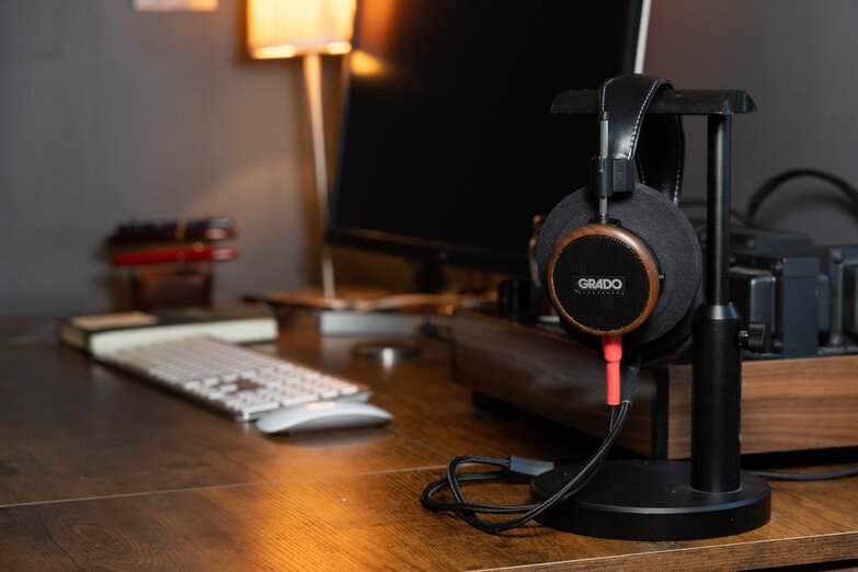 S550 headphones hanging on a stand on the desk beside the computer