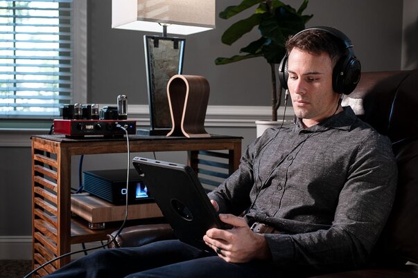 man wearing headphones using an Apple iPad