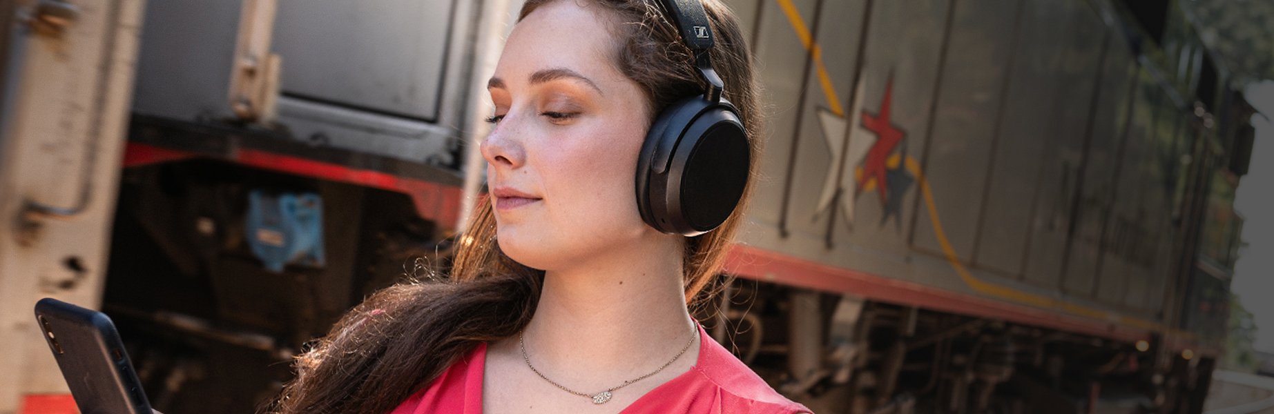 Woman listening to Sennheiser Momentum 4 Wireless Headphones