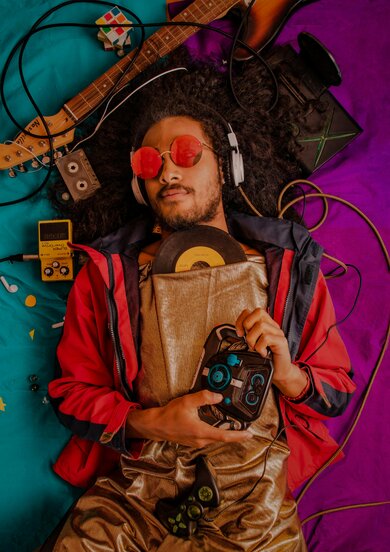 Man laying on ground surrounded by vintage audio gear